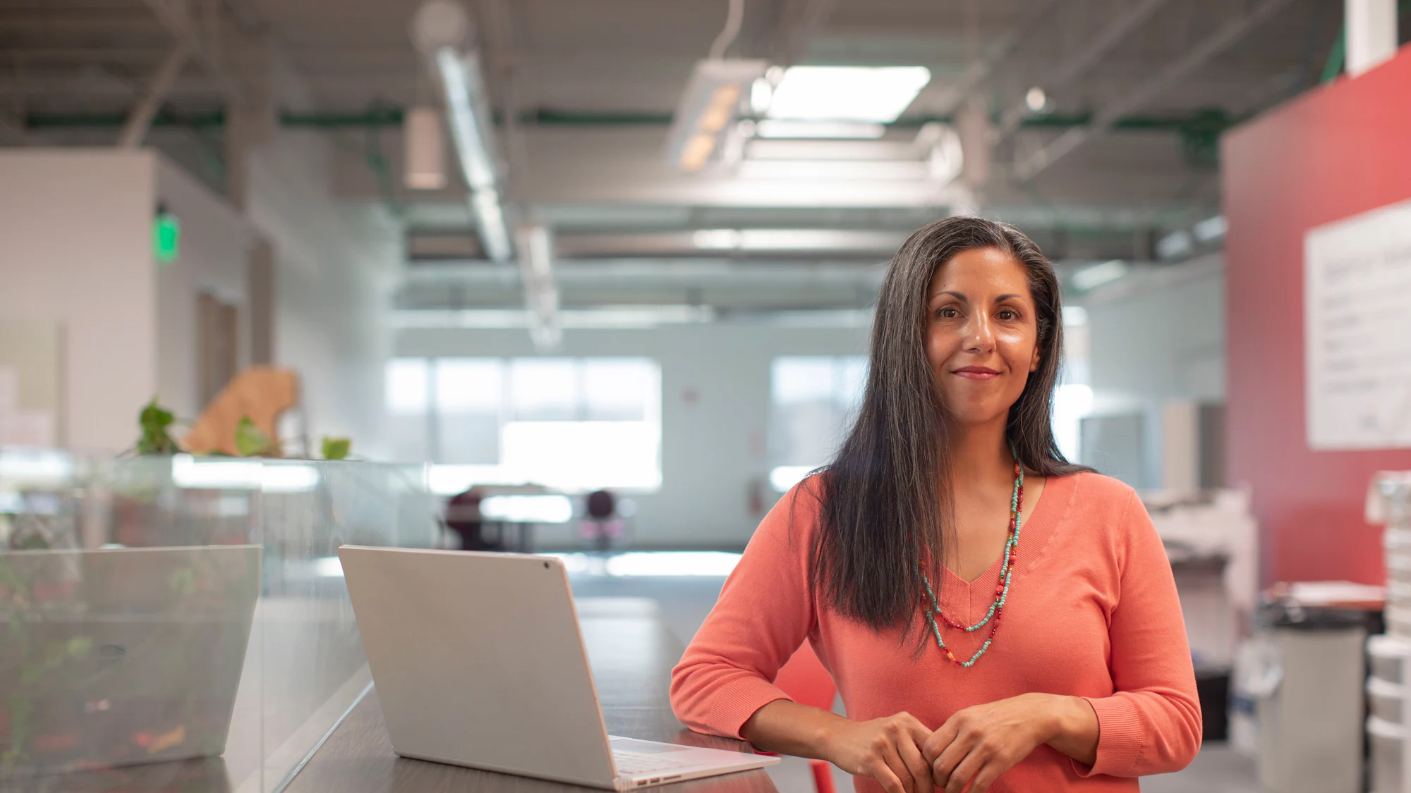 A woman working at a laptop in a bright open plan office