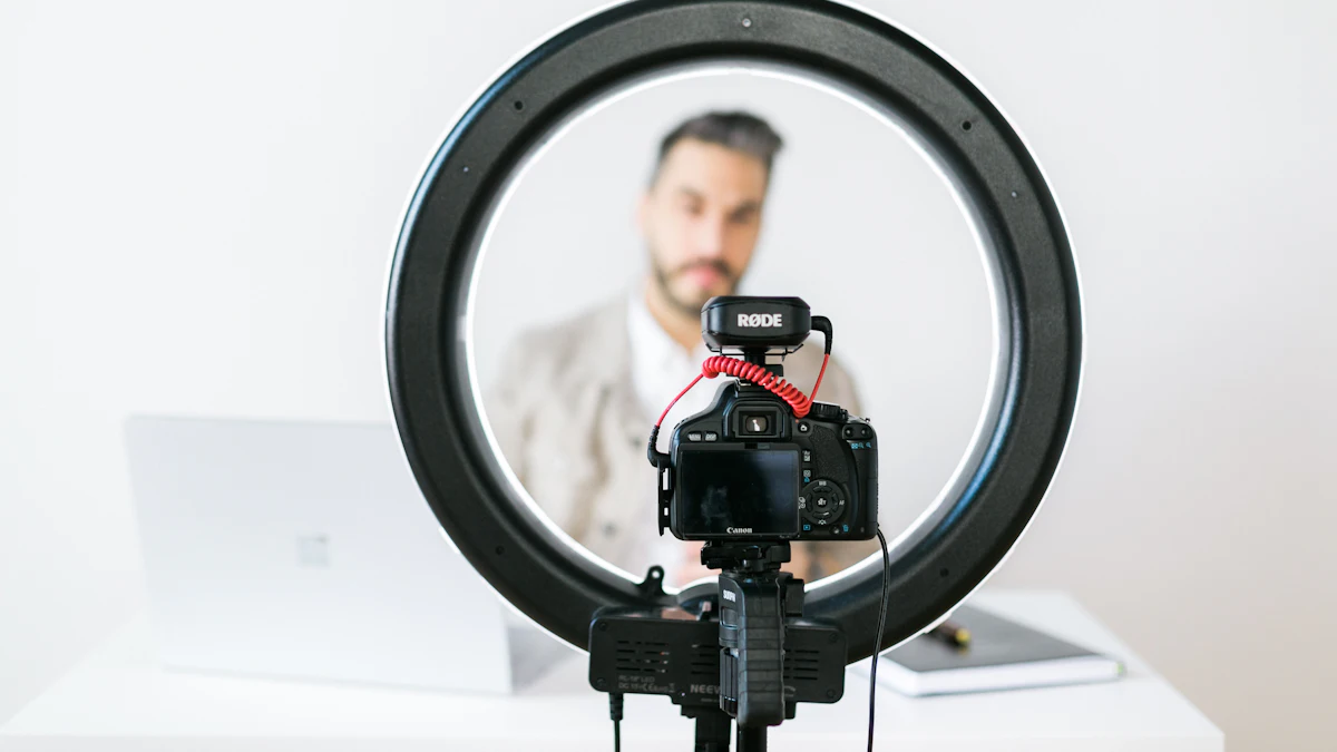 A camera with a microphone mounted in front of a ring light, a man sitting behind it