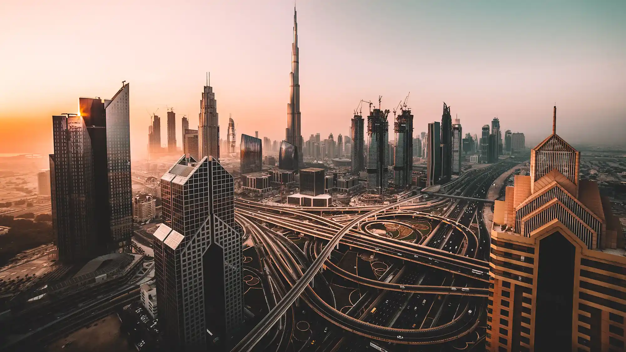 The Dubai skyline at dusk with city lights coming on