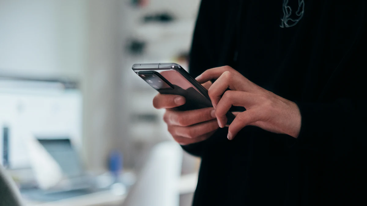 A person in a dark jacket typing a message on a smartphone